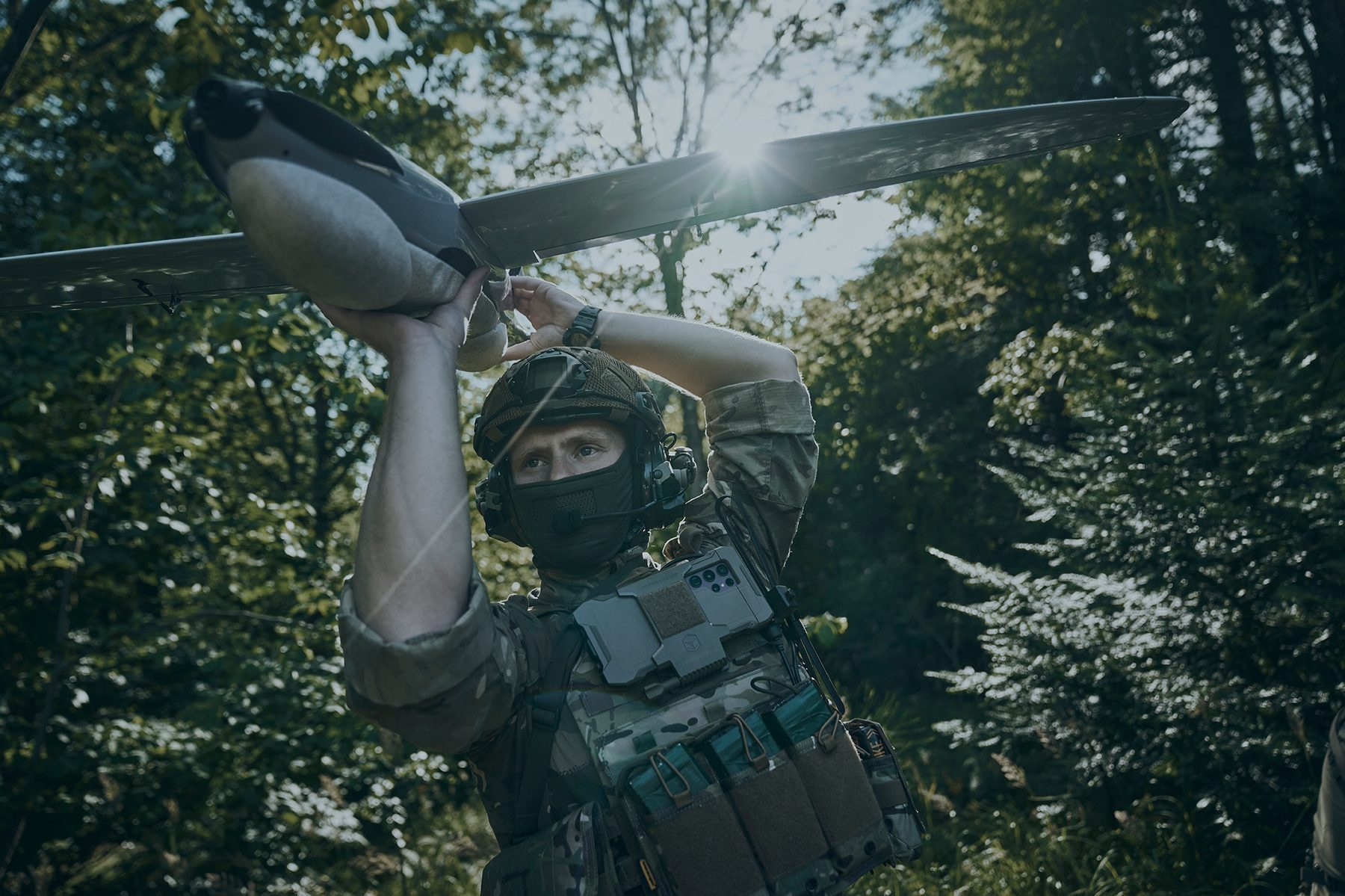 Operator carrying RQ-35 Heidrun in forest terrain