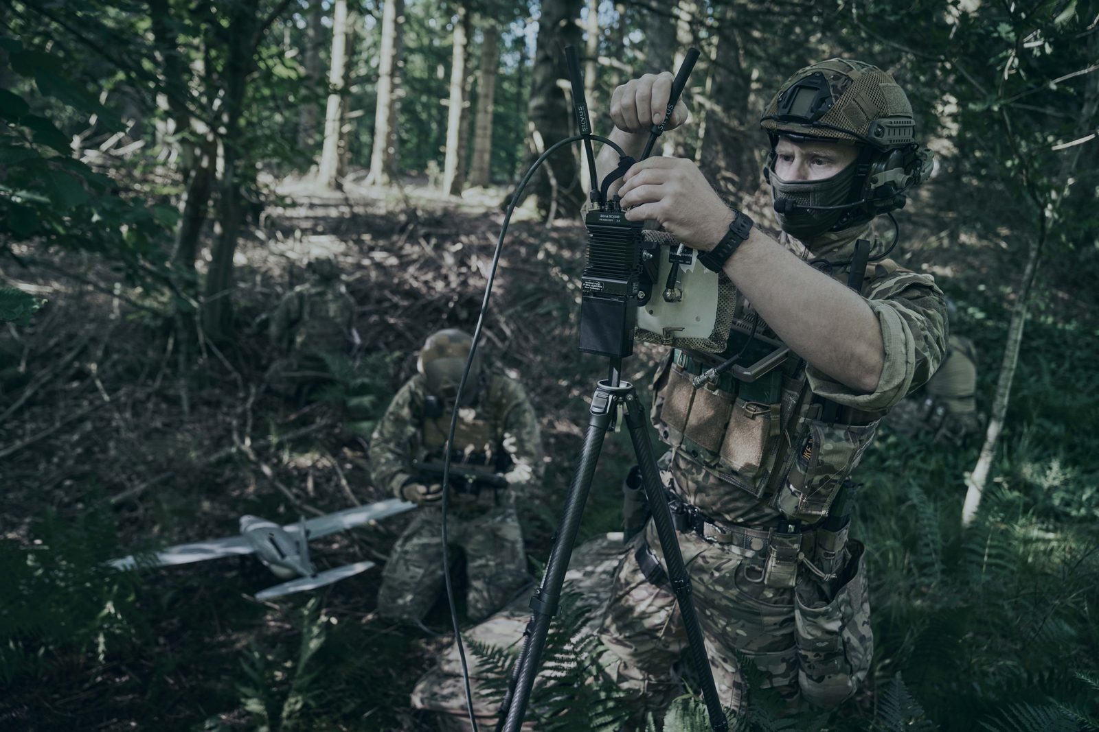 Persistent surveillance — operator at edge of treeline maintaining awareness